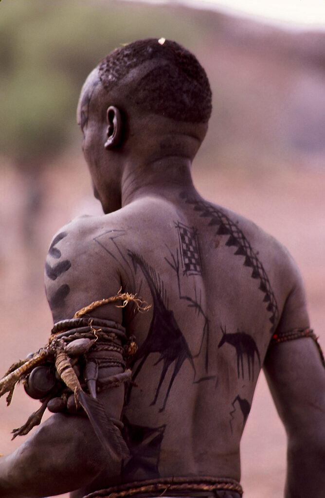 Le dos d’un jeune homme porte des représentations d’animaux, notamment une girafe. Nuba, Soudan. © Pierre Dubois.