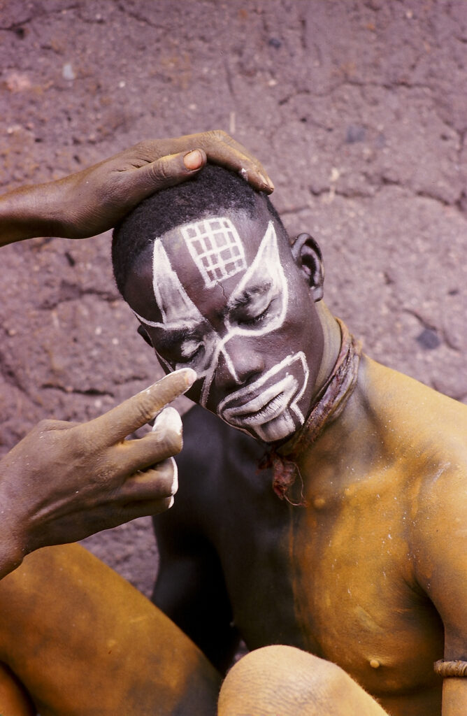 Décoration faciale d’un jeune homme par application de peinture. Nuba, Soudan. © Pierre Dubois.