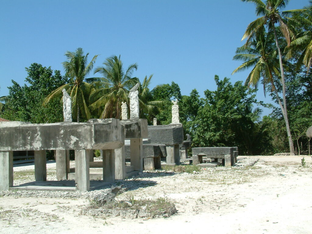 Les tombeaux des nobles de Rindi sont érigés au centre du village de Prai Yawang. Au premier plan, un cercle de pierres indique l’endroit où se trouvait l’arbre à crânes (andung), sur lequel étaient empalées les têtes coupées des ennemis du domaine. Île de Sumba. Photo : Georges Breguet.