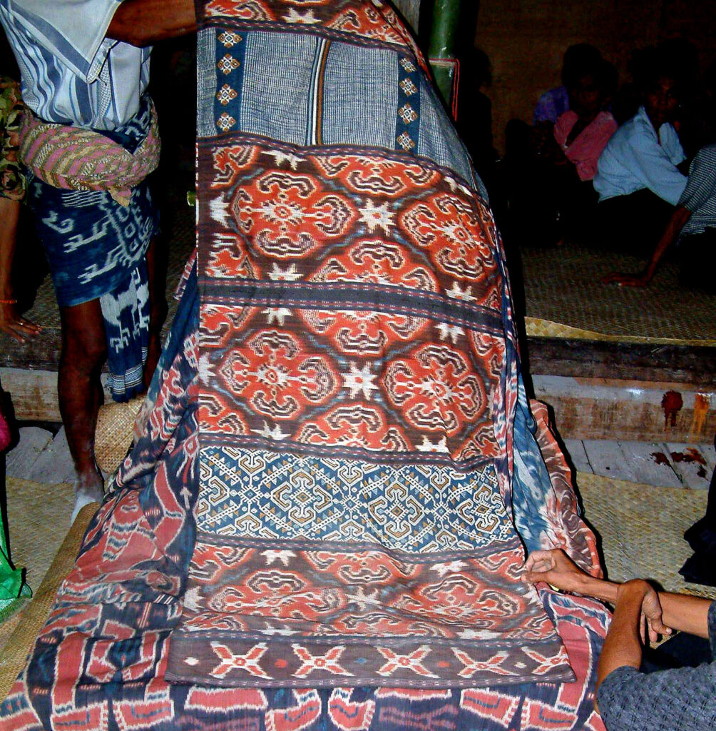 Le corps de la princesse Tamu Rambu Yuliana est installé dans la maison de cérémonie. Il est recouvert d’étoffes précieuses. Une échelle en bambou (visible à l’arrière-plan) est placée afin de faciliter l’ascension de son âme vers le ciel. Novembre 2002. Photo : Georges Bréguet.