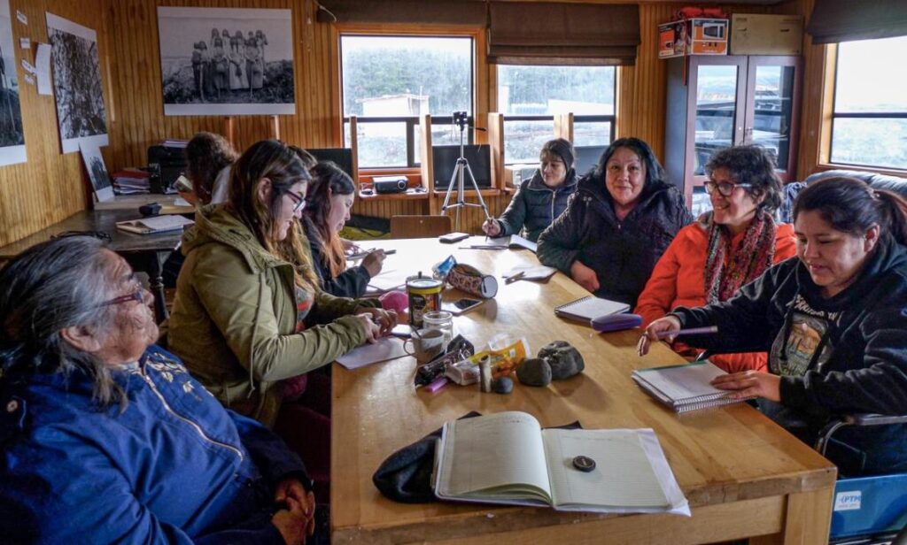 Atelier de langue yagan (octobre 2019). Avec Cristina Calderón et Cristina Zárraga, communauté yagan de Villa Ukika. Aux murs, une exposition de photographies « anthropologiques » du passé.